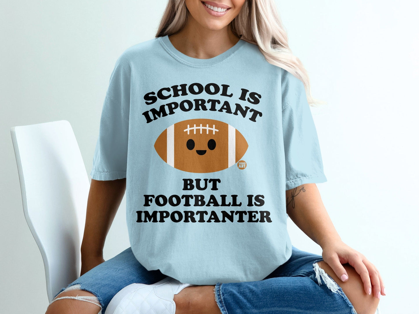 Light blue t-shirt with football graphic and "School is important but football is importanter" text.