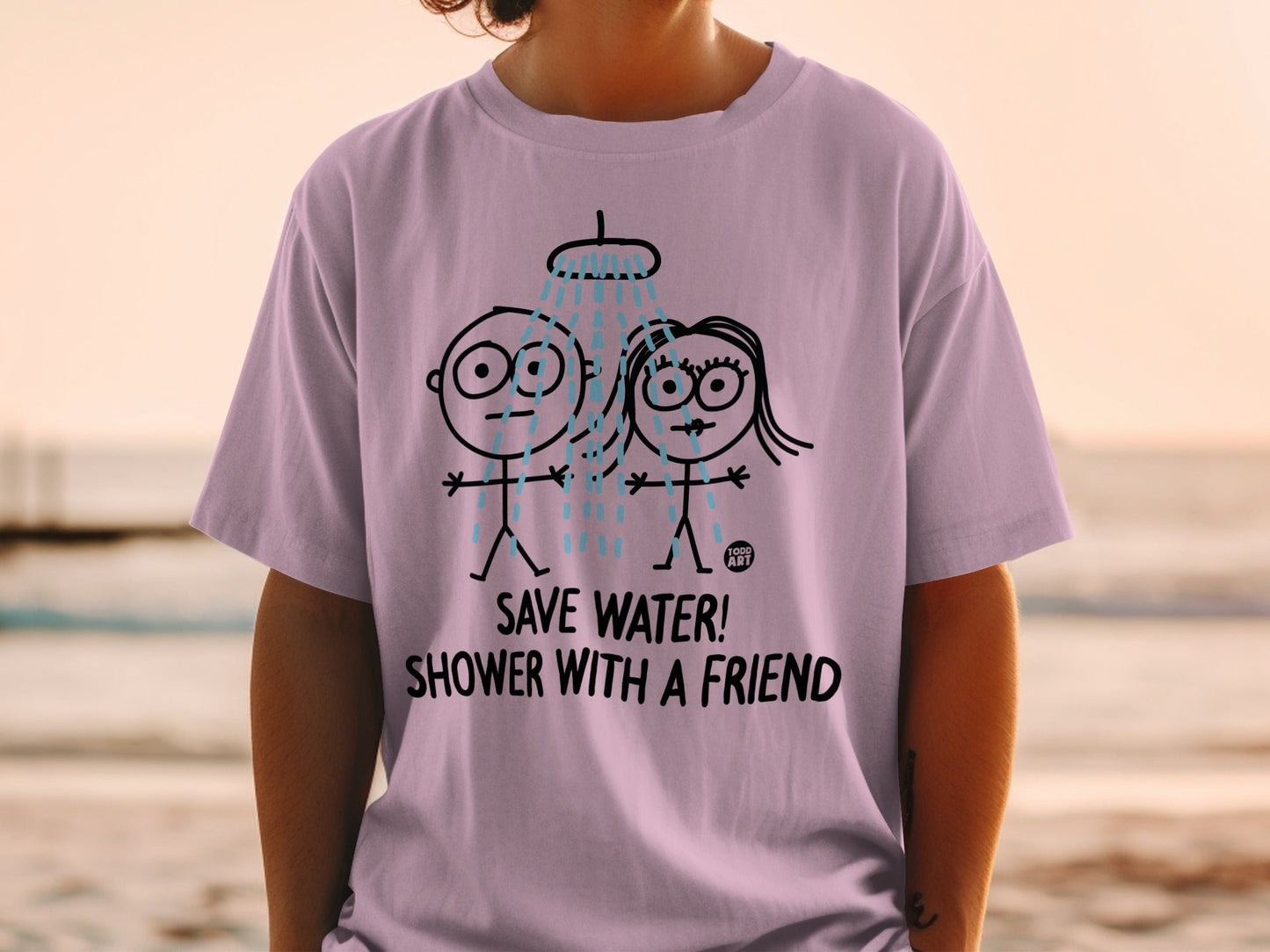 Lilac t-shirt with cartoon figures showering and text "SAVE WATER! SHOWER WITH A FRIEND".