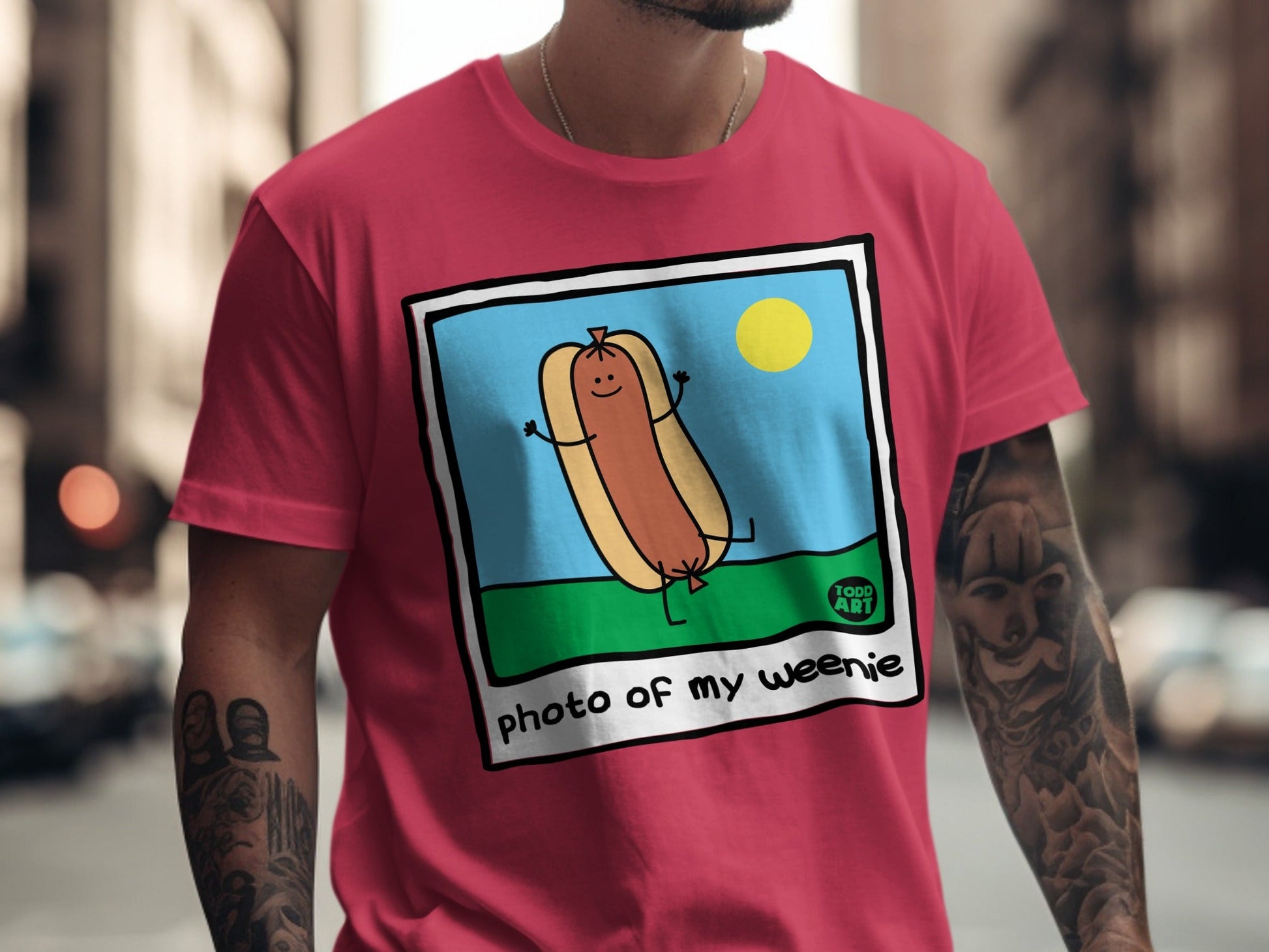 Cartoon hot dog with arms and legs on a t-shirt, reads "photo of my weenie".