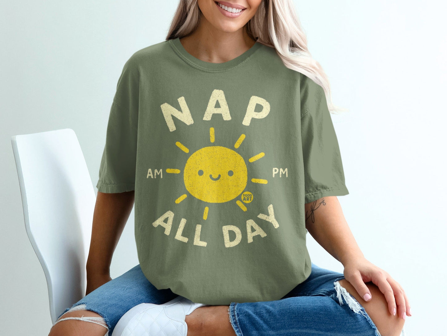 Olive green t-shirt with "Nap All Day" text and smiling sun graphic.