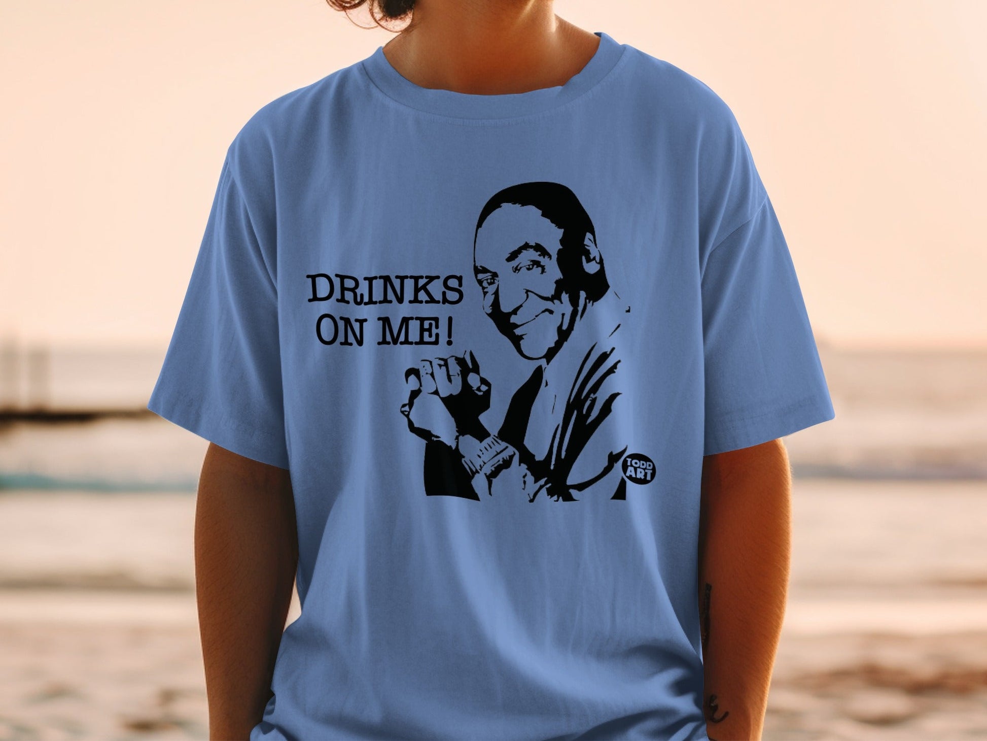 T-shirt with "DRINKS ON ME!" text and a smiling man illustration.