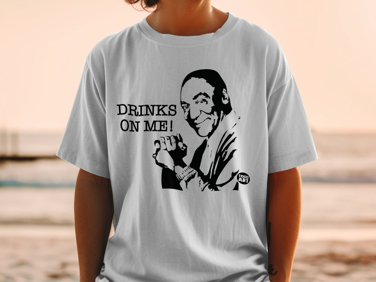 T-shirt with a black and white graphic of a man and the text "DRINKS ON ME!".