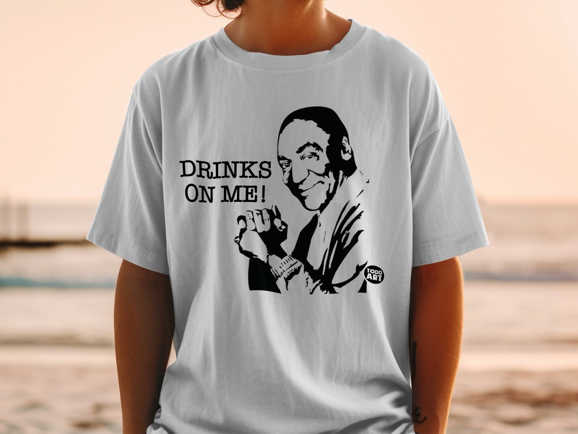 T-shirt with a black and white graphic of a man and the text "DRINKS ON ME!".