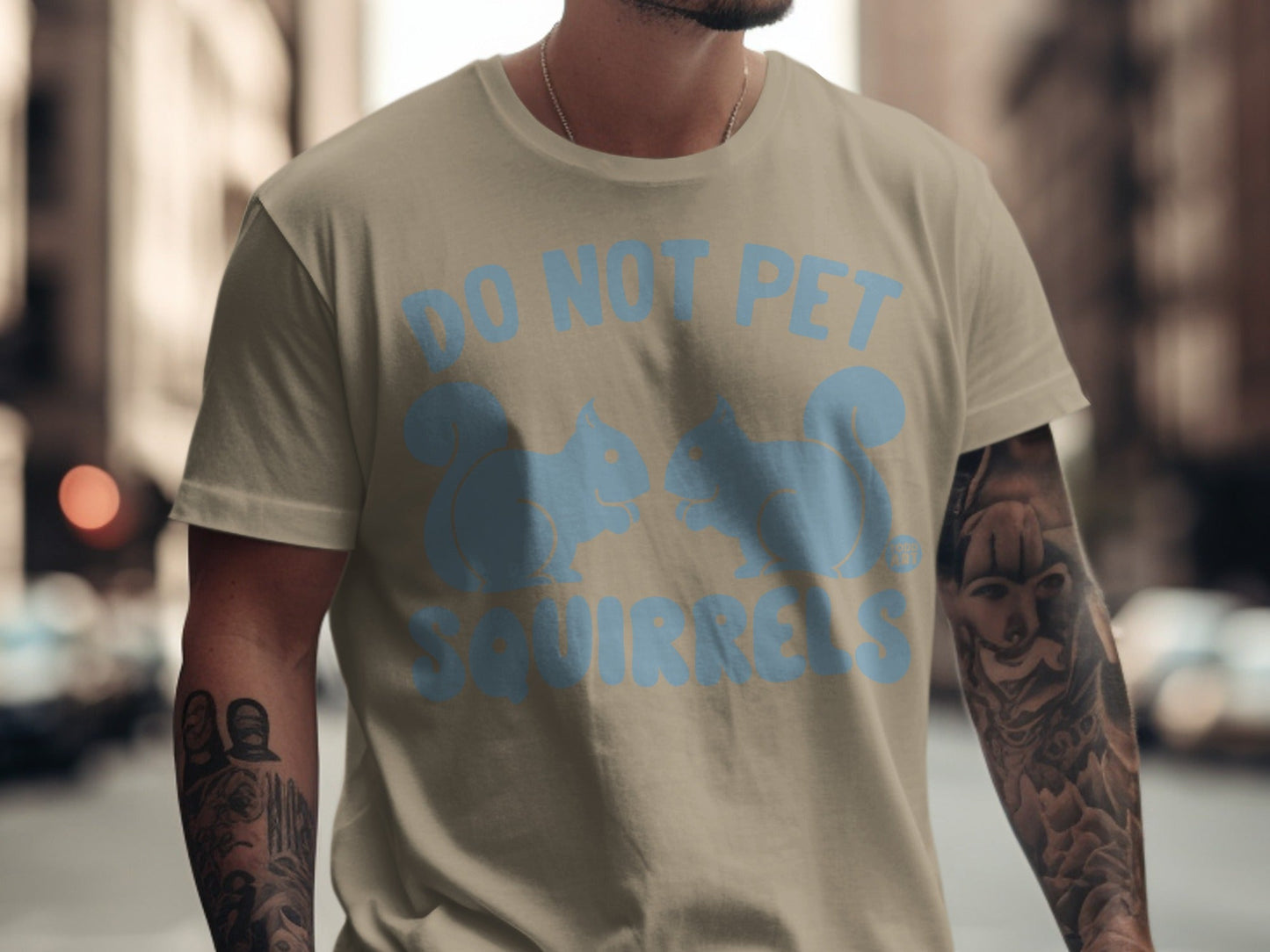 Tan t-shirt with light blue silhouette of two squirrels and "DO NOT PET SQUIRRELS" text.