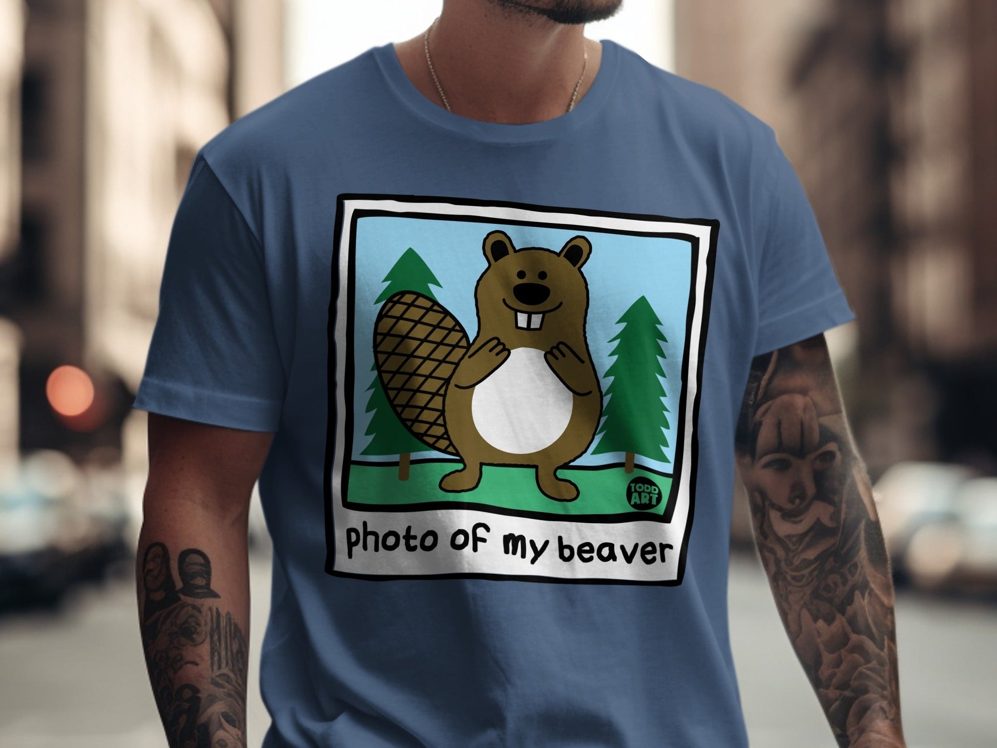 Cartoon beaver with large teeth and bushy tail on a blue t-shirt.