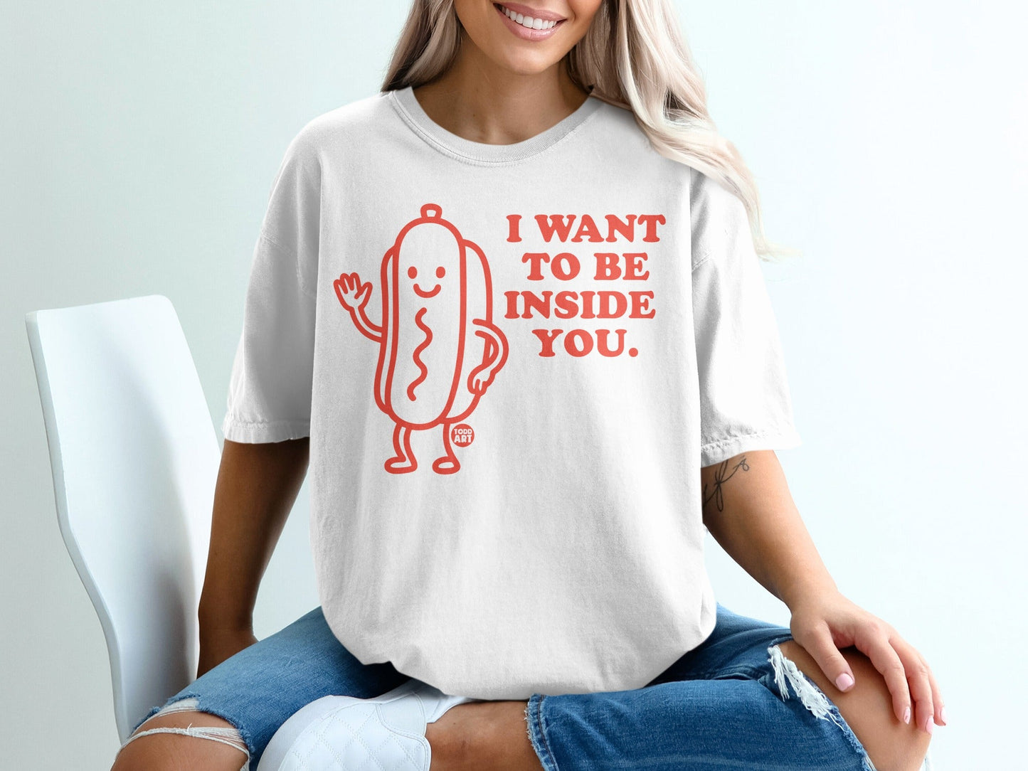 White t-shirt with a cartoon hot dog saying "I want to be inside you."