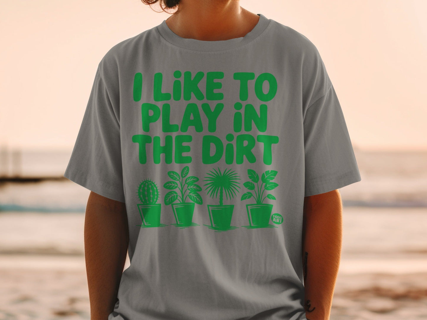 Grey t-shirt with "I LIKE TO PLAY IN THE DIRT" and plant graphics.