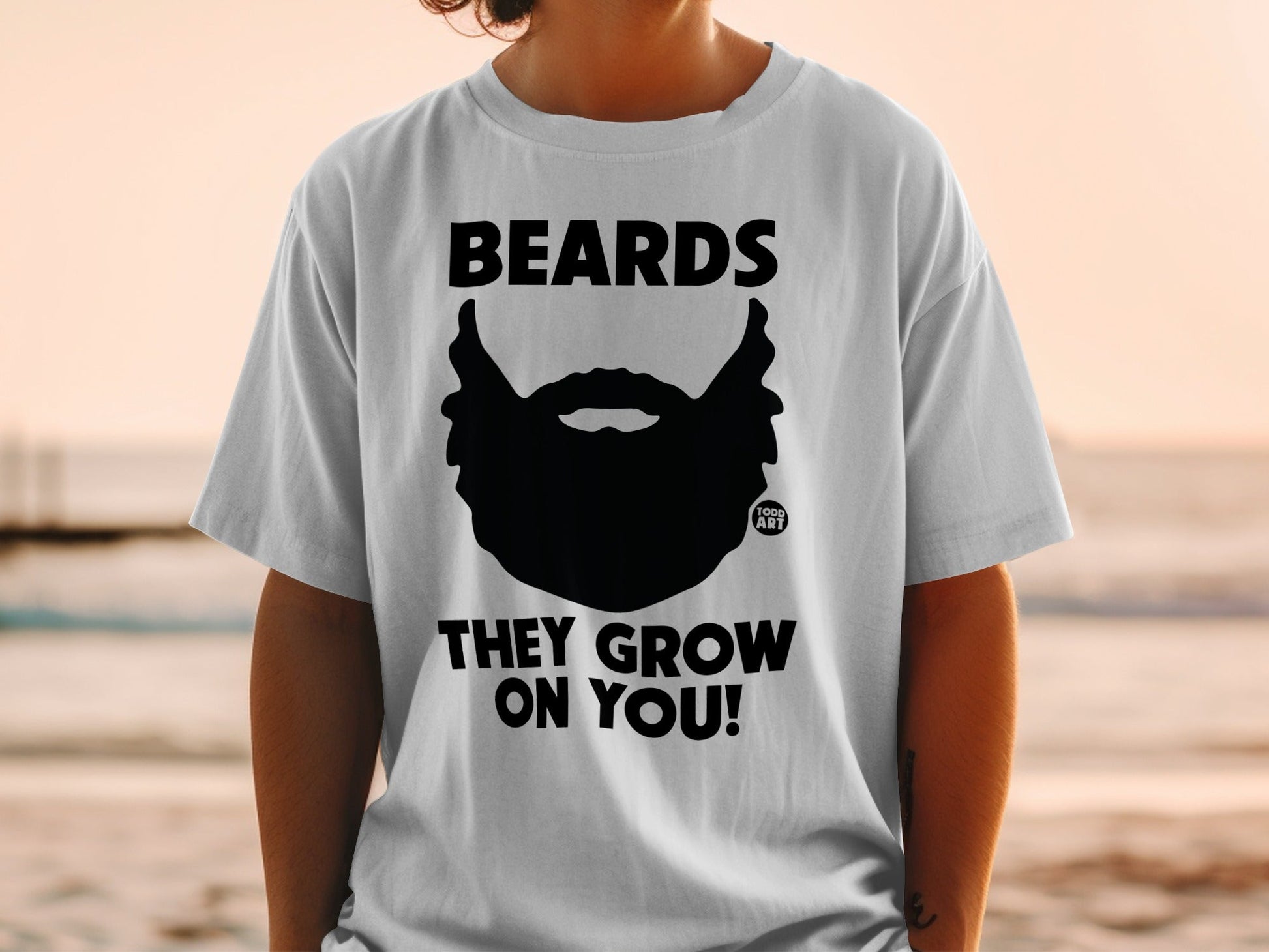Black beard graphic with "BEARDS THEY GROW ON YOU!" text on white t-shirt.