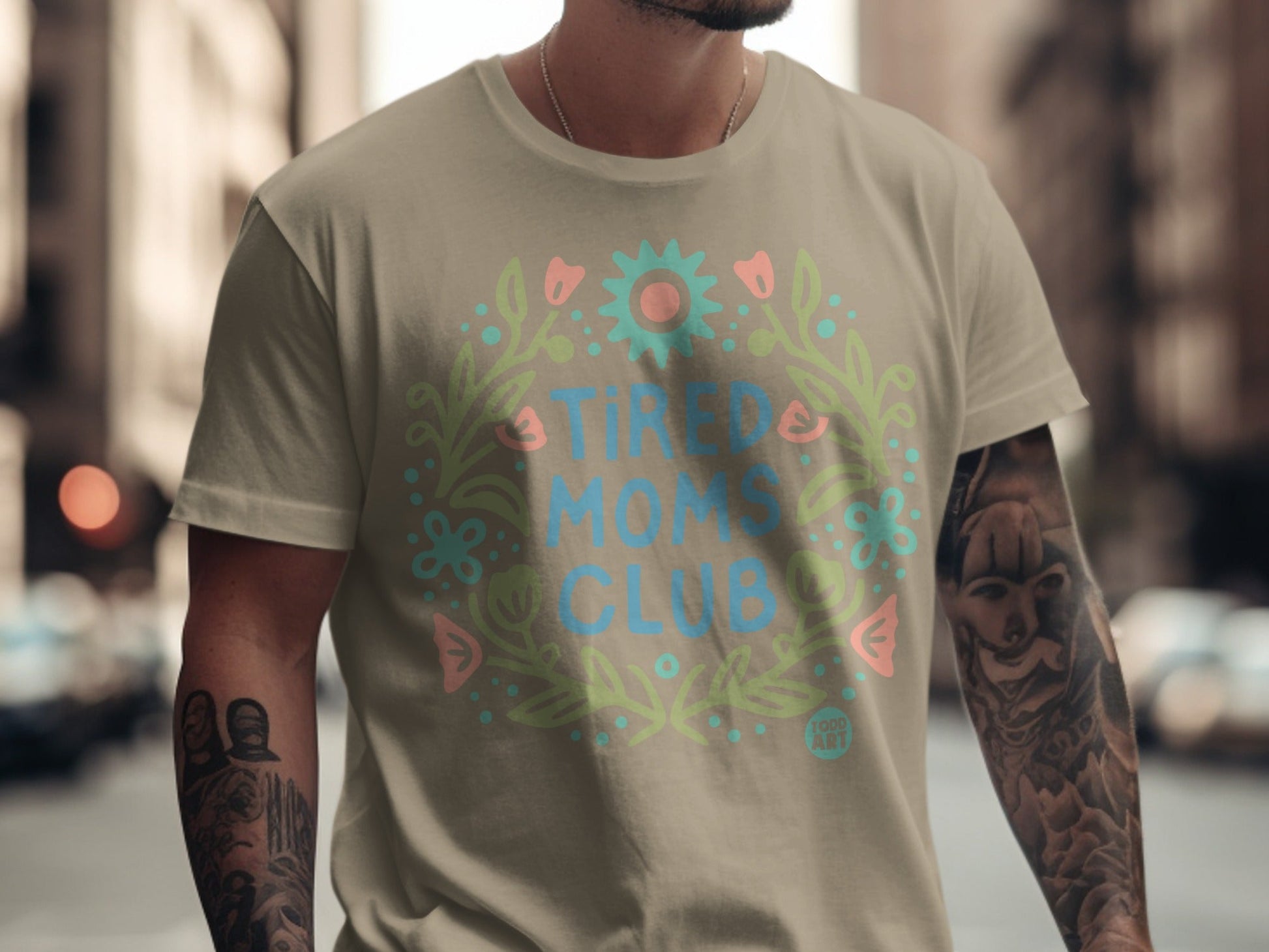 Tan t-shirt with floral wreath and "Tired Moms Club" text.