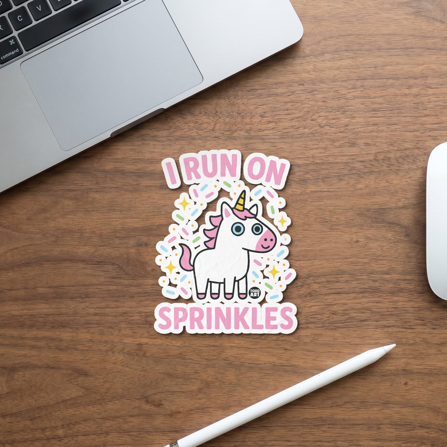 Sticker with white cartoon unicorn surrounded by sprinkles and text "I RUN ON SPRINKLES".
