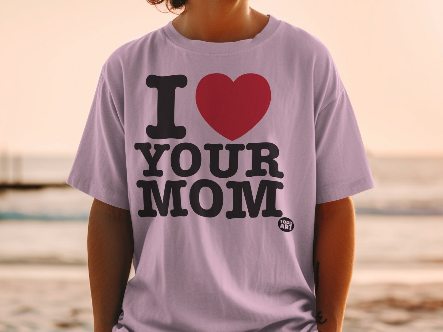 Lilac t-shirt with bold black text "I ‚ù§Ô∏è YOUR MOM" and a small "FOOD ART" logo.