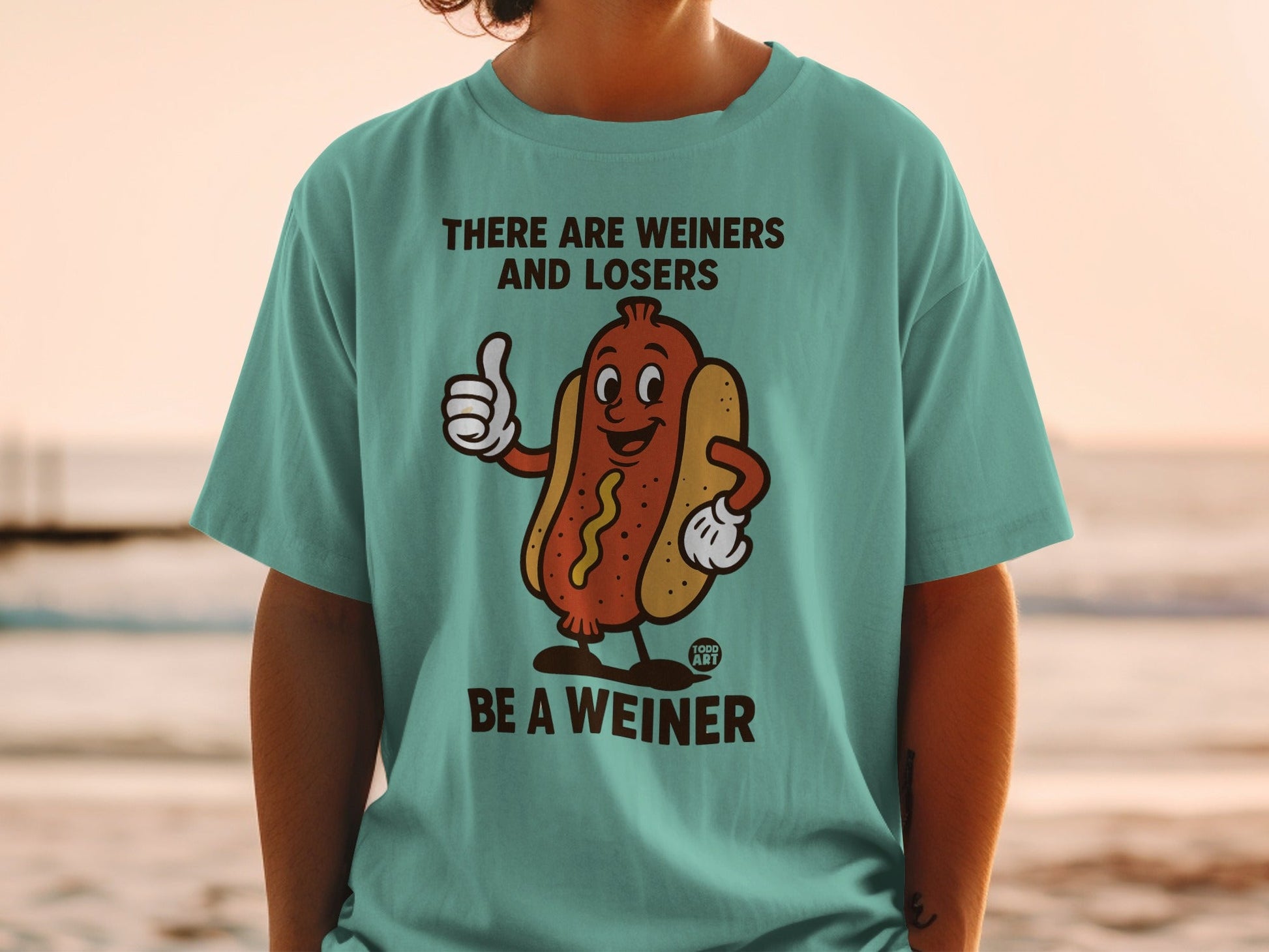 T-shirt with cartoon hot dog giving a thumbs up and text "THERE ARE WEINERS AND LOSERS BE A WEINER".