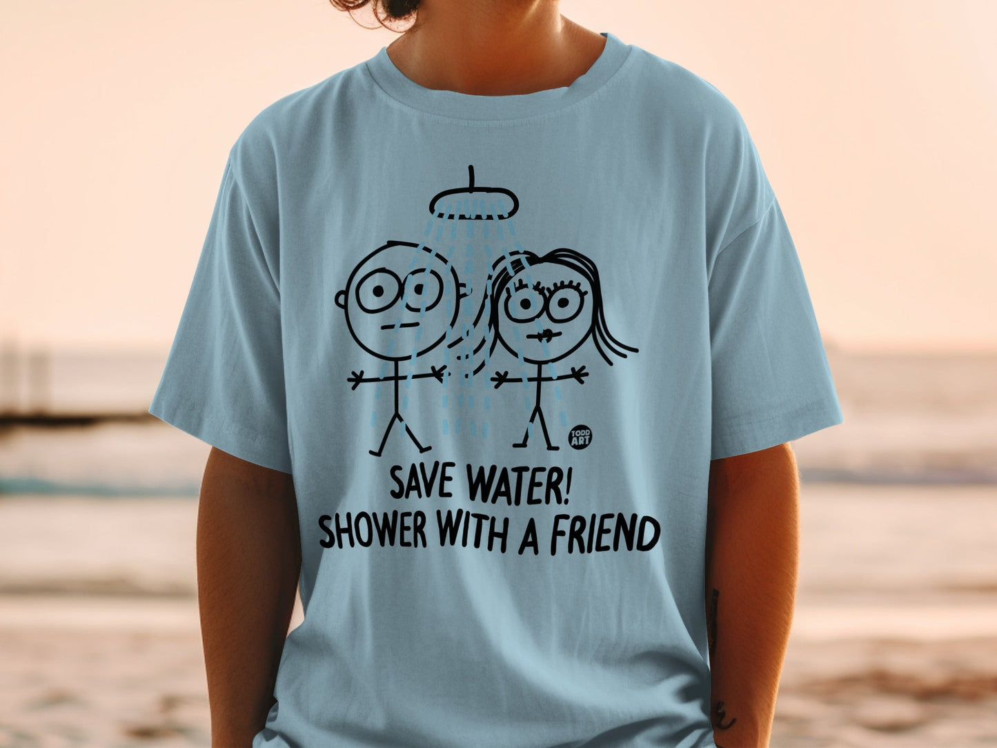 Light blue t-shirt with cartoon figures showering and text "SAVE WATER! SHOWER WITH A FRIEND".