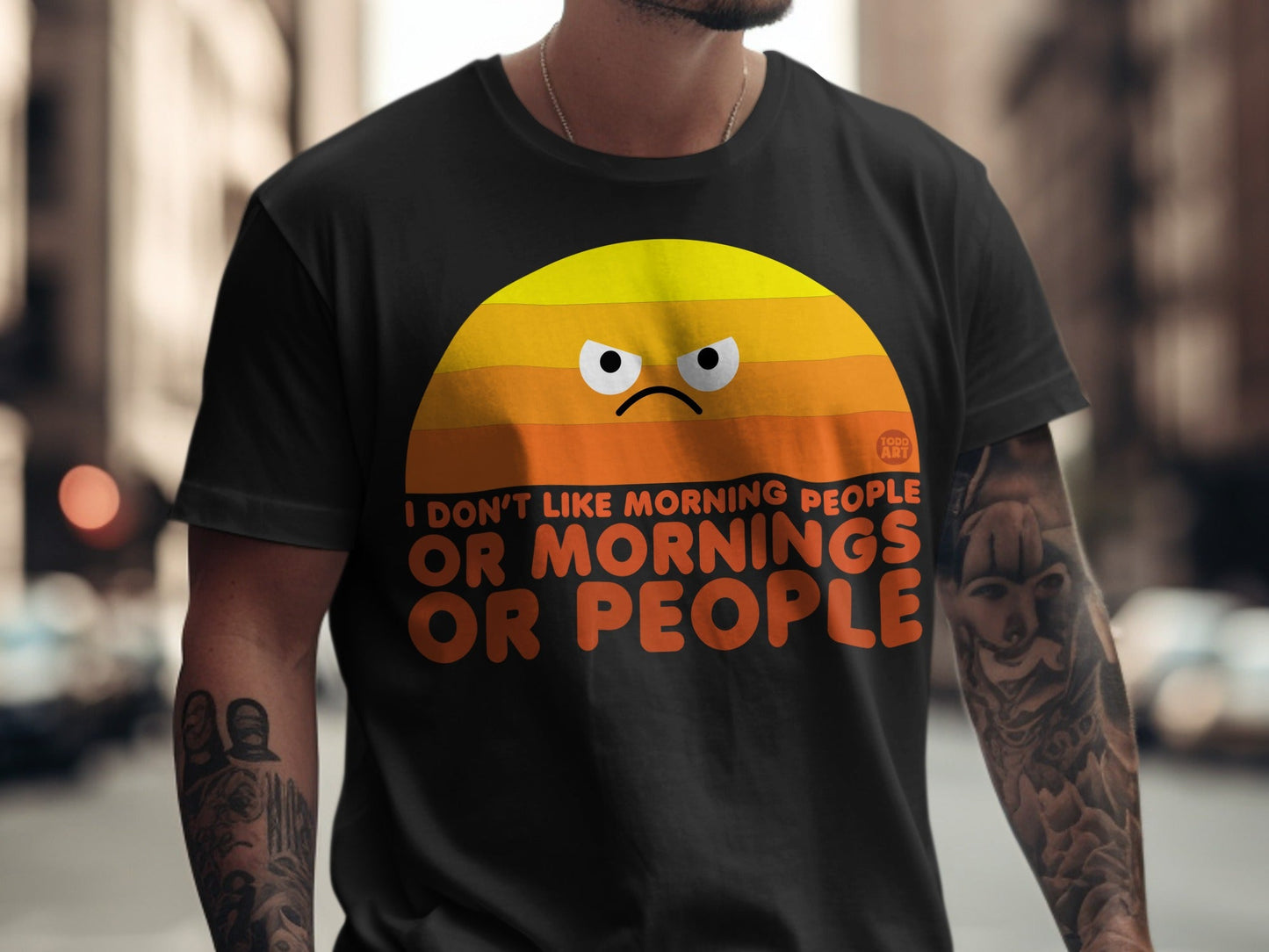 Black t-shirt with an angry sun graphic and "I DON'T LIKE MORNING PEOPLE OR MORNINGS OR PEOPLE".