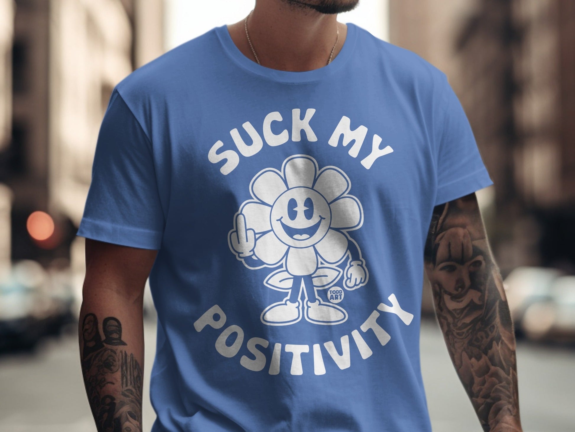 Blue t-shirt with cartoon flower giving middle finger, "Suck My Positivity" text.