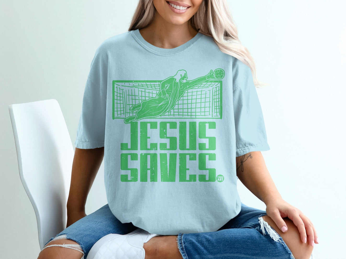 Light blue t-shirt with "Jesus Saves" and a goalie graphic.