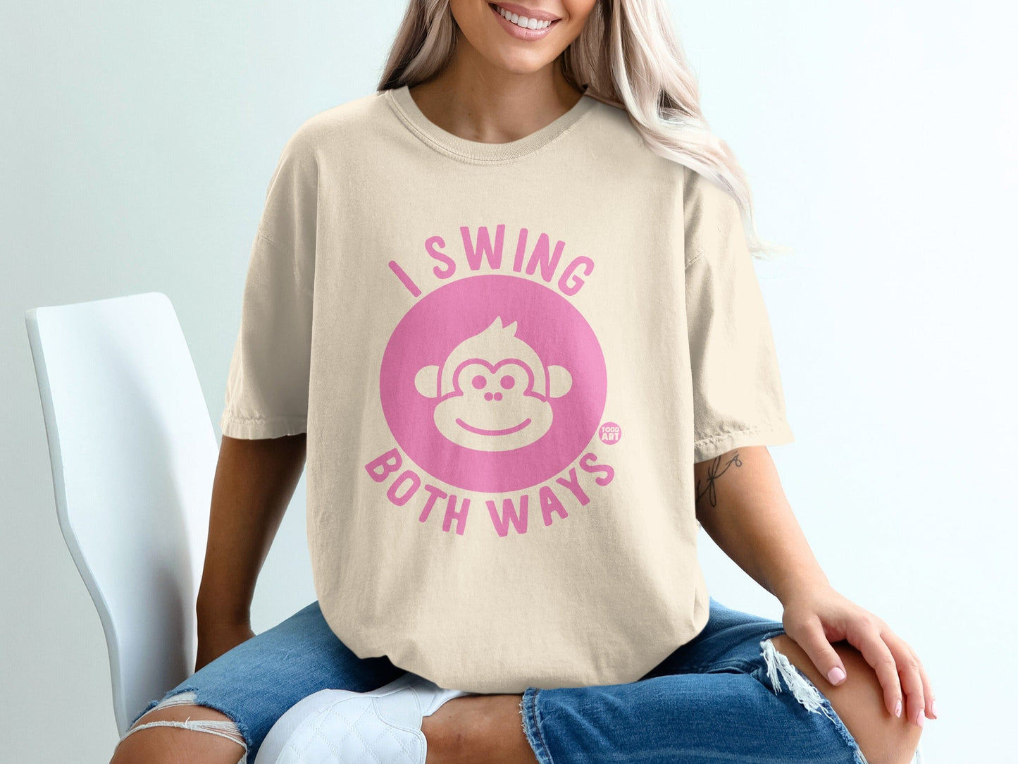 Cream t-shirt with pink "I swing both ways" text and monkey face graphic.