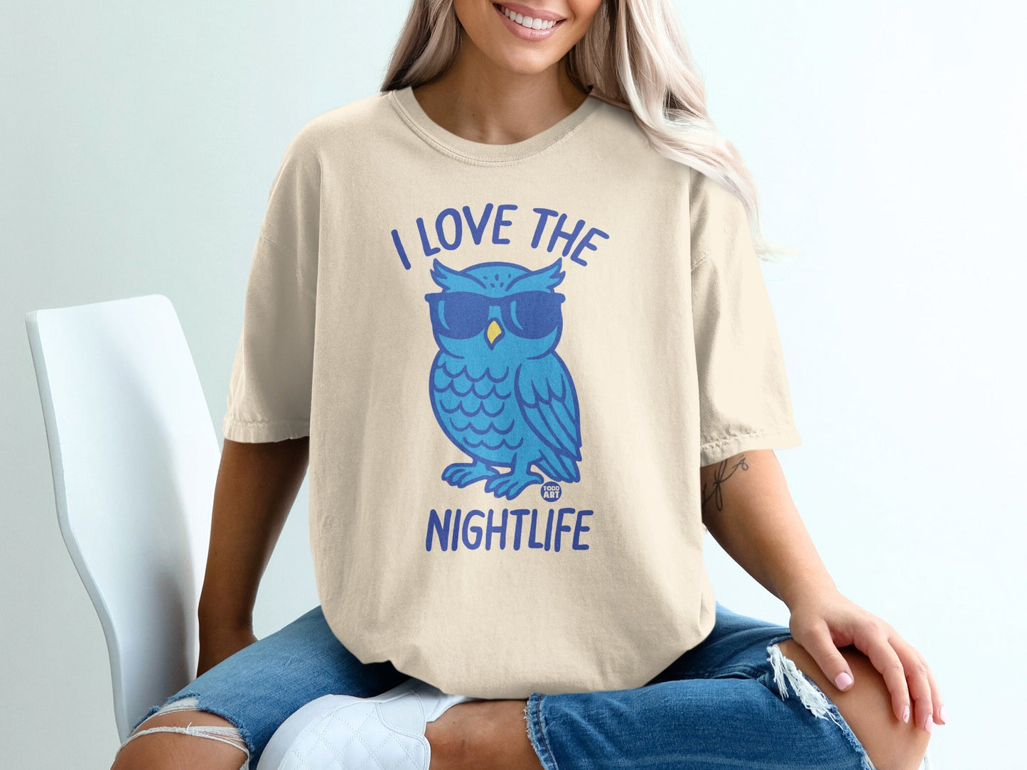 Cream t-shirt with a blue cartoon owl wearing sunglasses and text "I LOVE THE NIGHTLIFE".