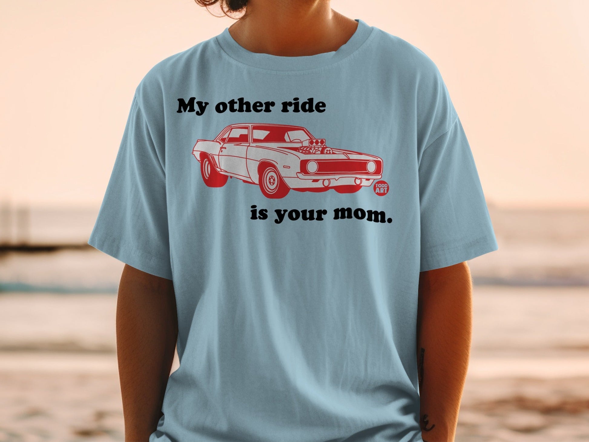 Light blue t-shirt with red graphic of a vintage muscle car and text.