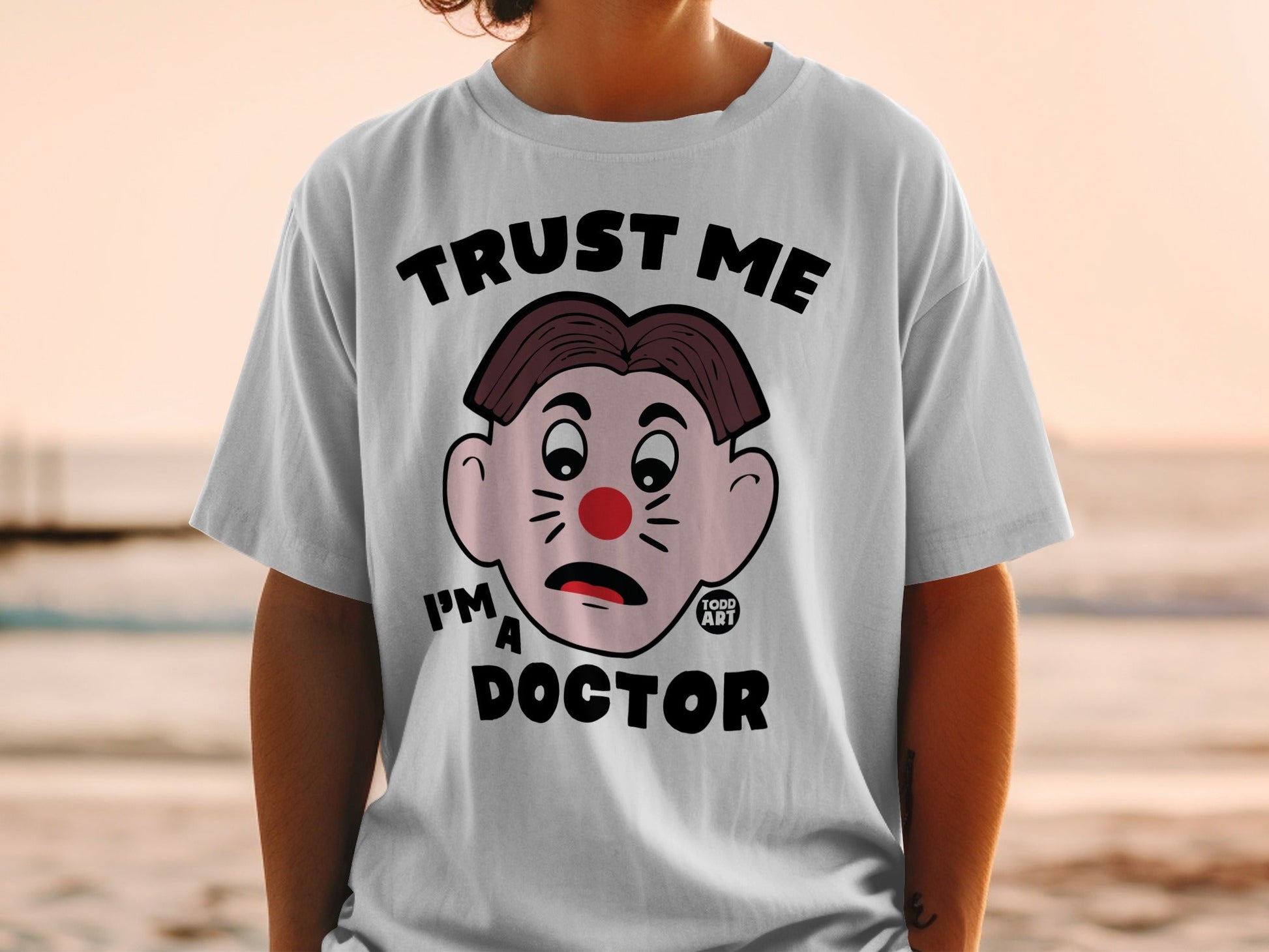 White t-shirt with cartoon face saying "Trust Me I'm a Doctor".