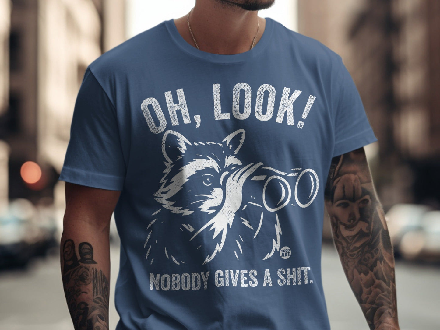 T-shirt with raccoon looking through binoculars and text "OH, LOOK! NOBODY GIVES A SHIT."