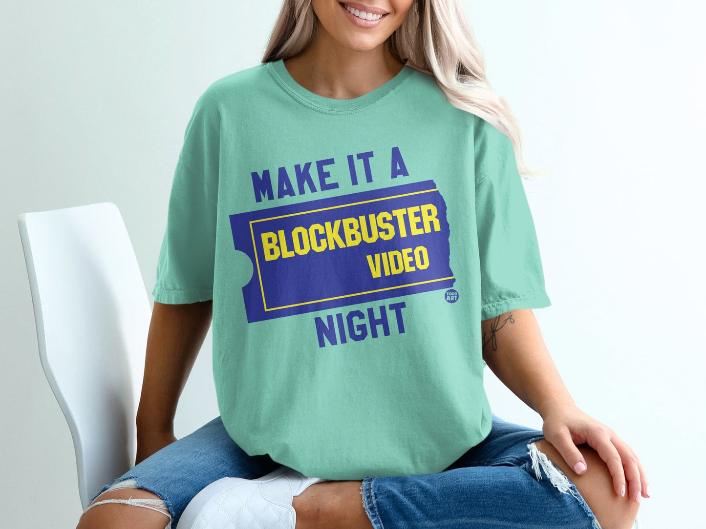 Teal t-shirt with "Make it a Blockbuster Night" text in yellow and purple.
