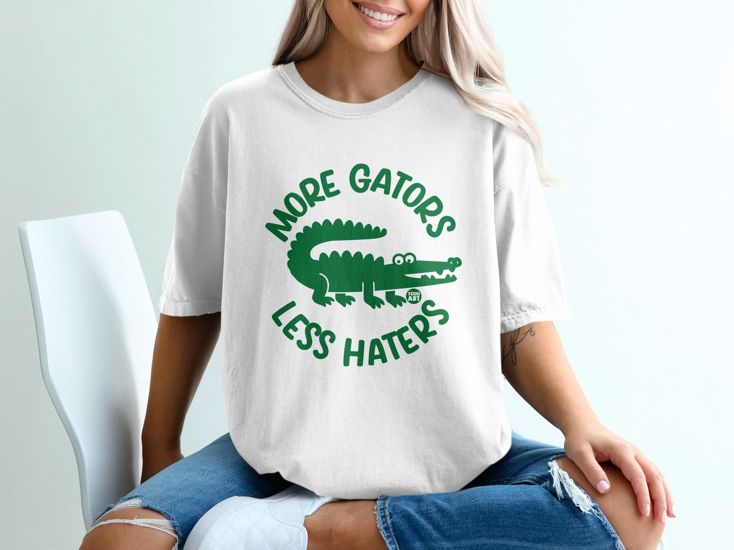 White t-shirt with green text and alligator graphic that reads "More Gators Less Haters".