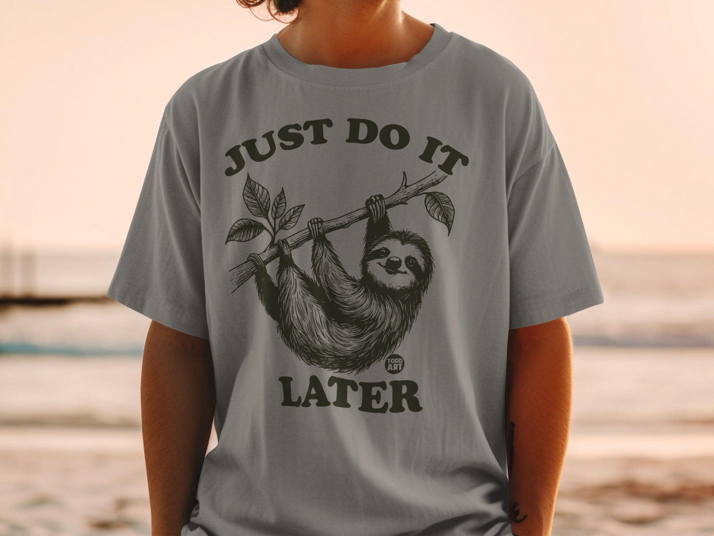 T-shirt with a sloth hanging from a branch, text "JUST DO IT LATER".