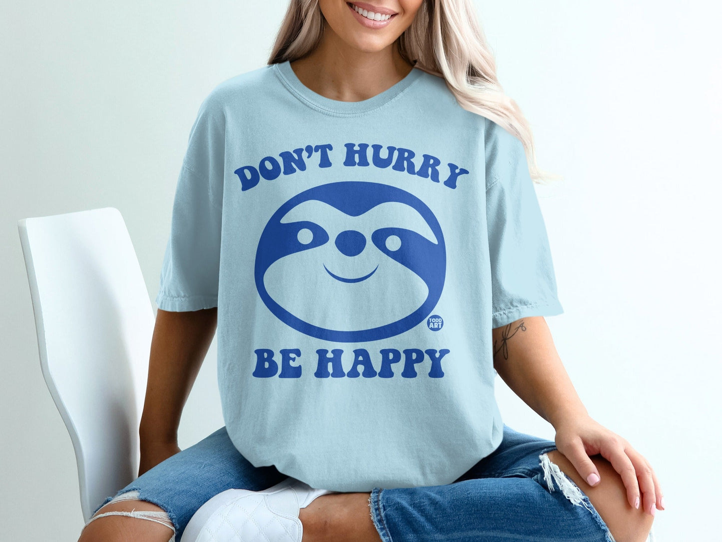 Light blue t-shirt with sloth graphic and text "Don't Hurry Be Happy".