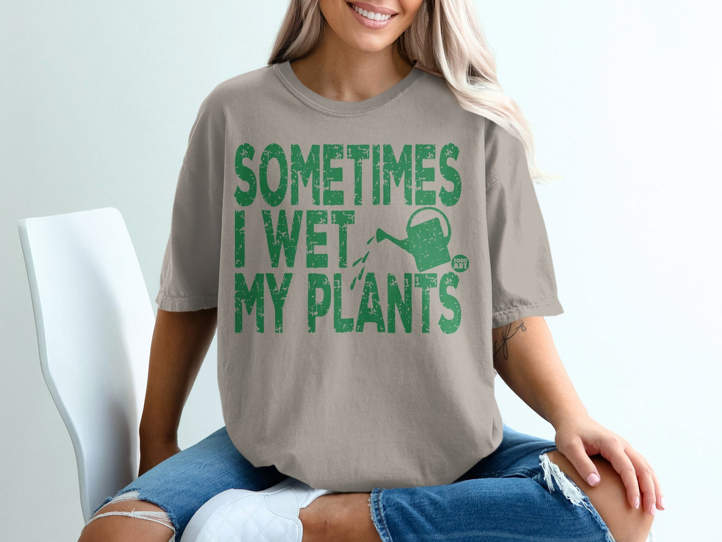 T-shirt with green text "SOMETIMES I WET MY PLANTS" and a watering can.