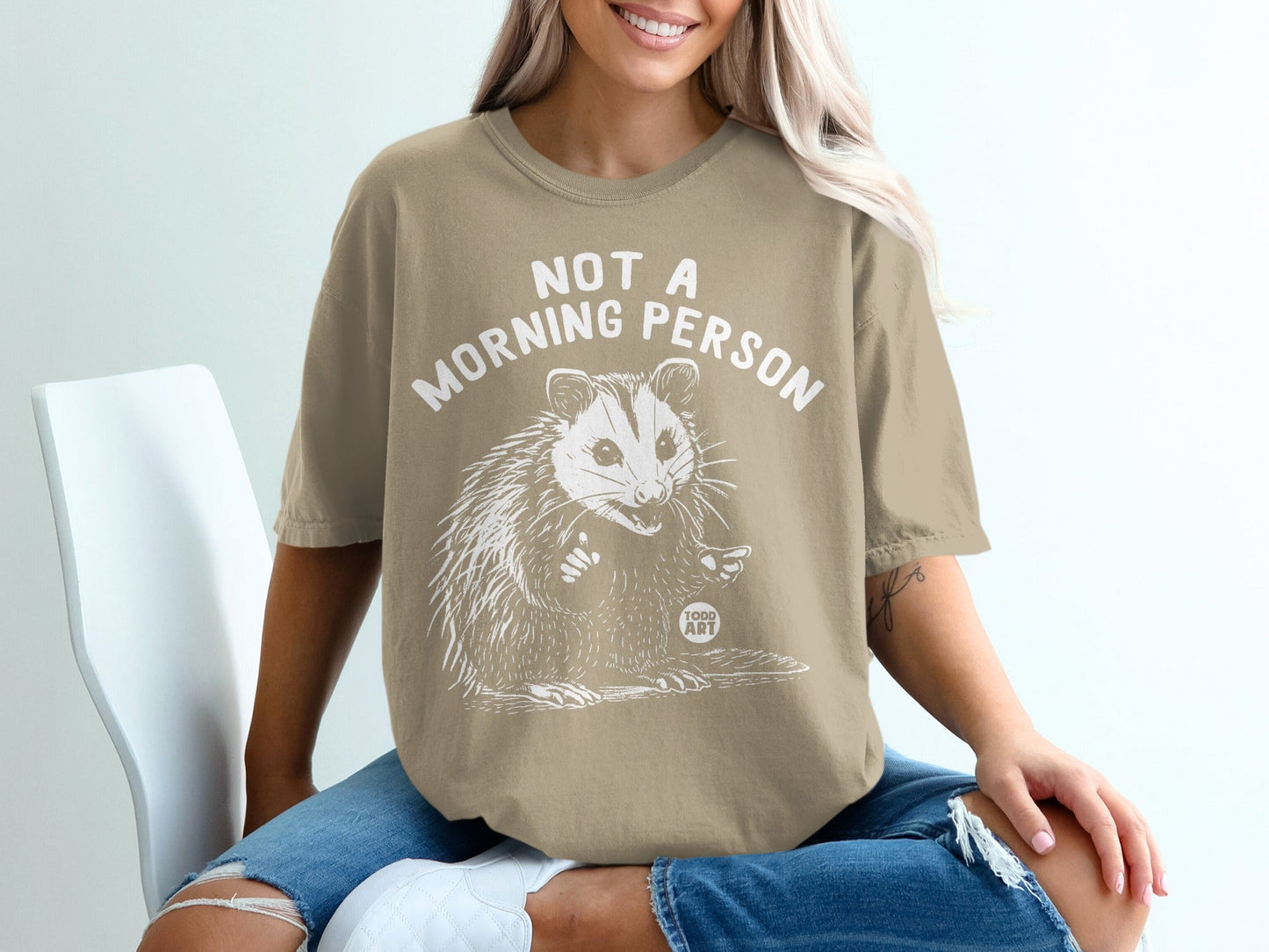 Tan t-shirt with white line art of a possum and "NOT A MORNING PERSON" text.