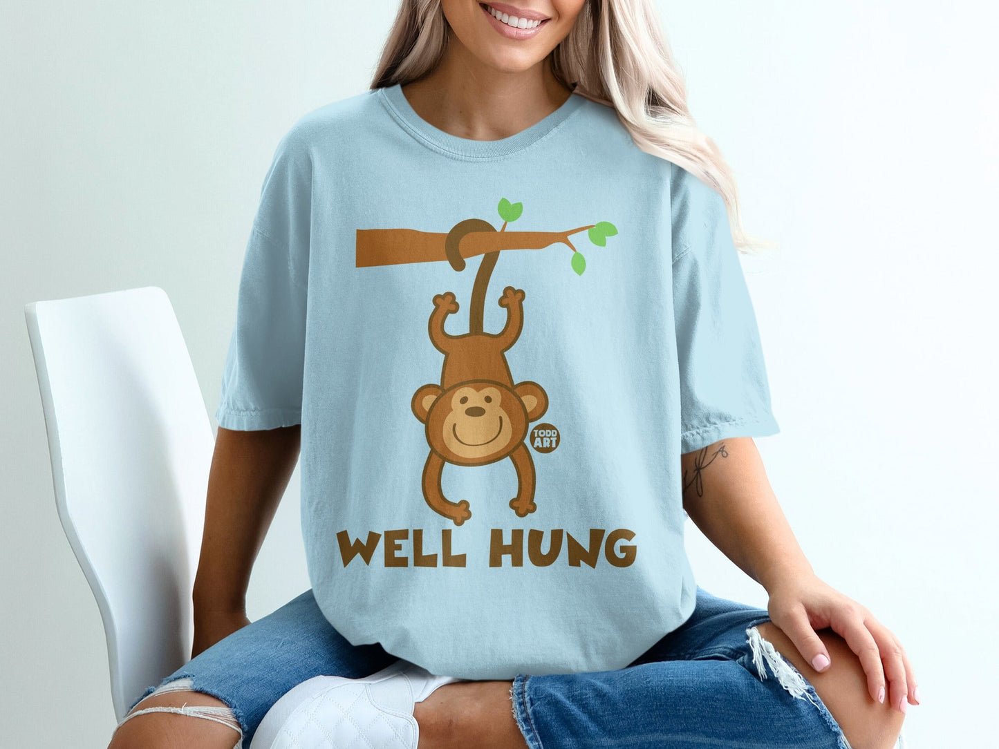 Light blue t-shirt with cartoon monkey hanging from a branch, "WELL HUNG" text.