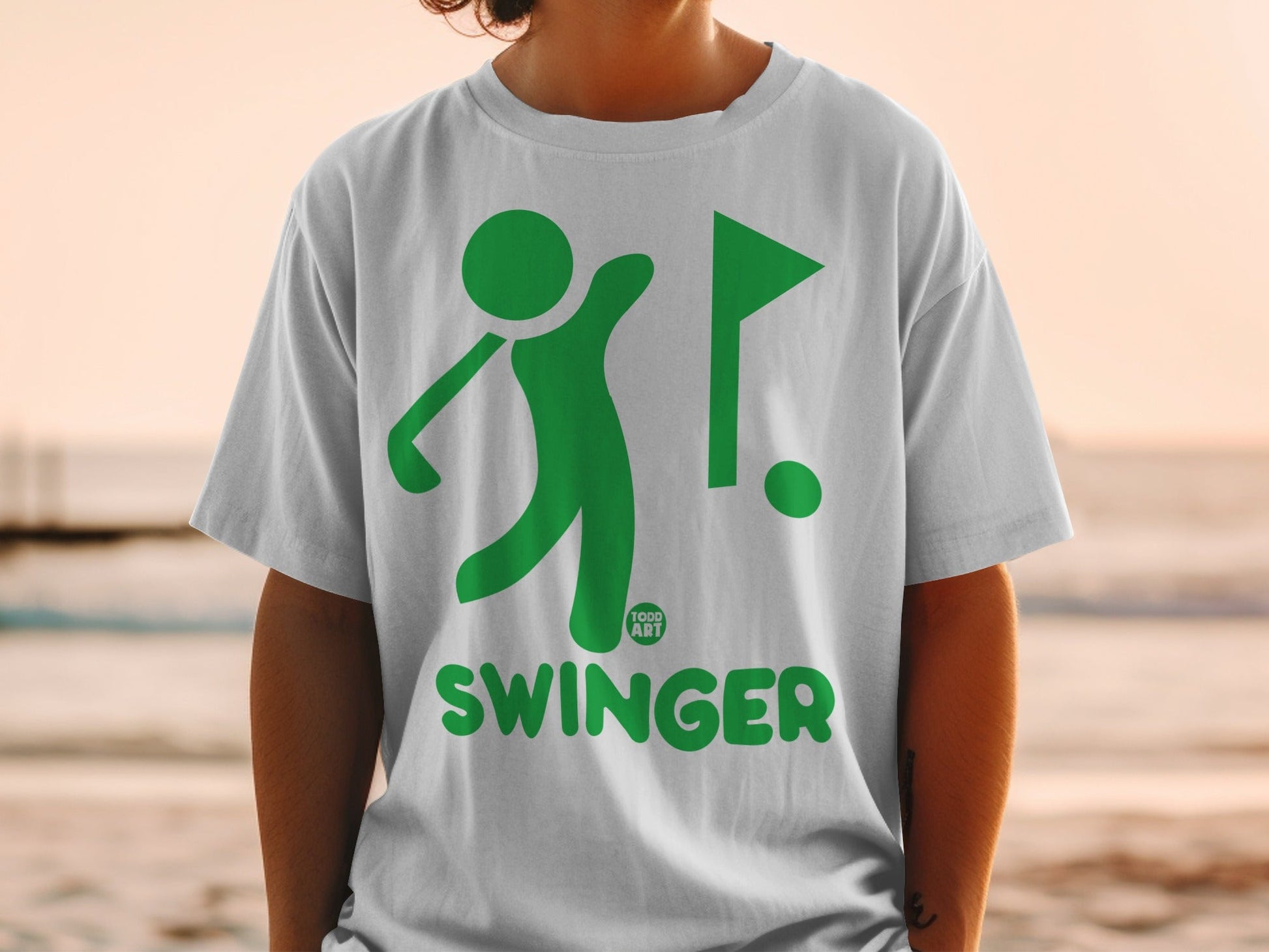 White t-shirt with green graphic of a golfer and the word "SWINGER".