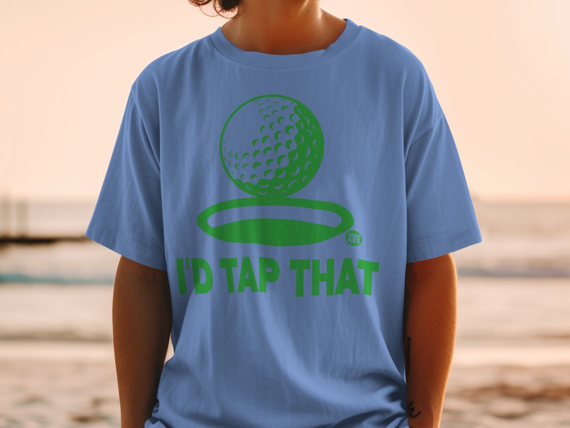 Blue t-shirt with green golf ball graphic and text "I'D TAP THAT".