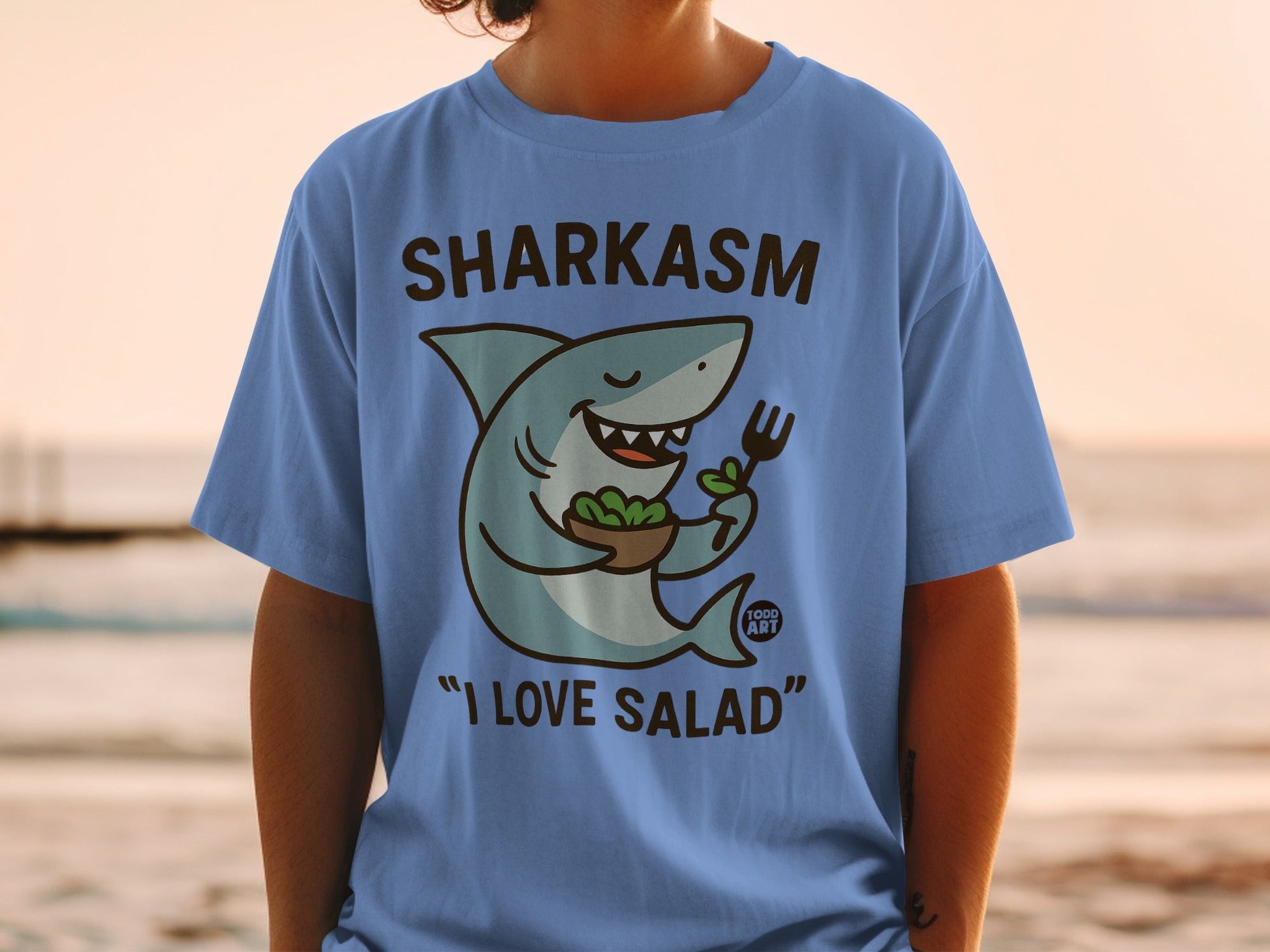 Blue t-shirt with a cartoon shark holding a salad bowl and fork, saying "I LOVE SALAD".