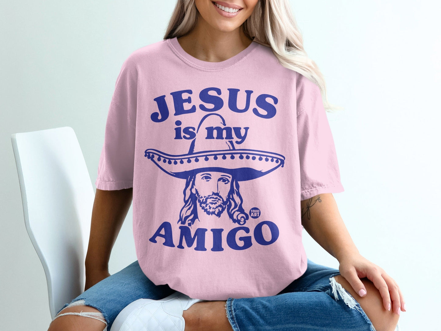 Pink t-shirt with "Jesus is my amigo" text and a sombrero-wearing Jesus graphic.