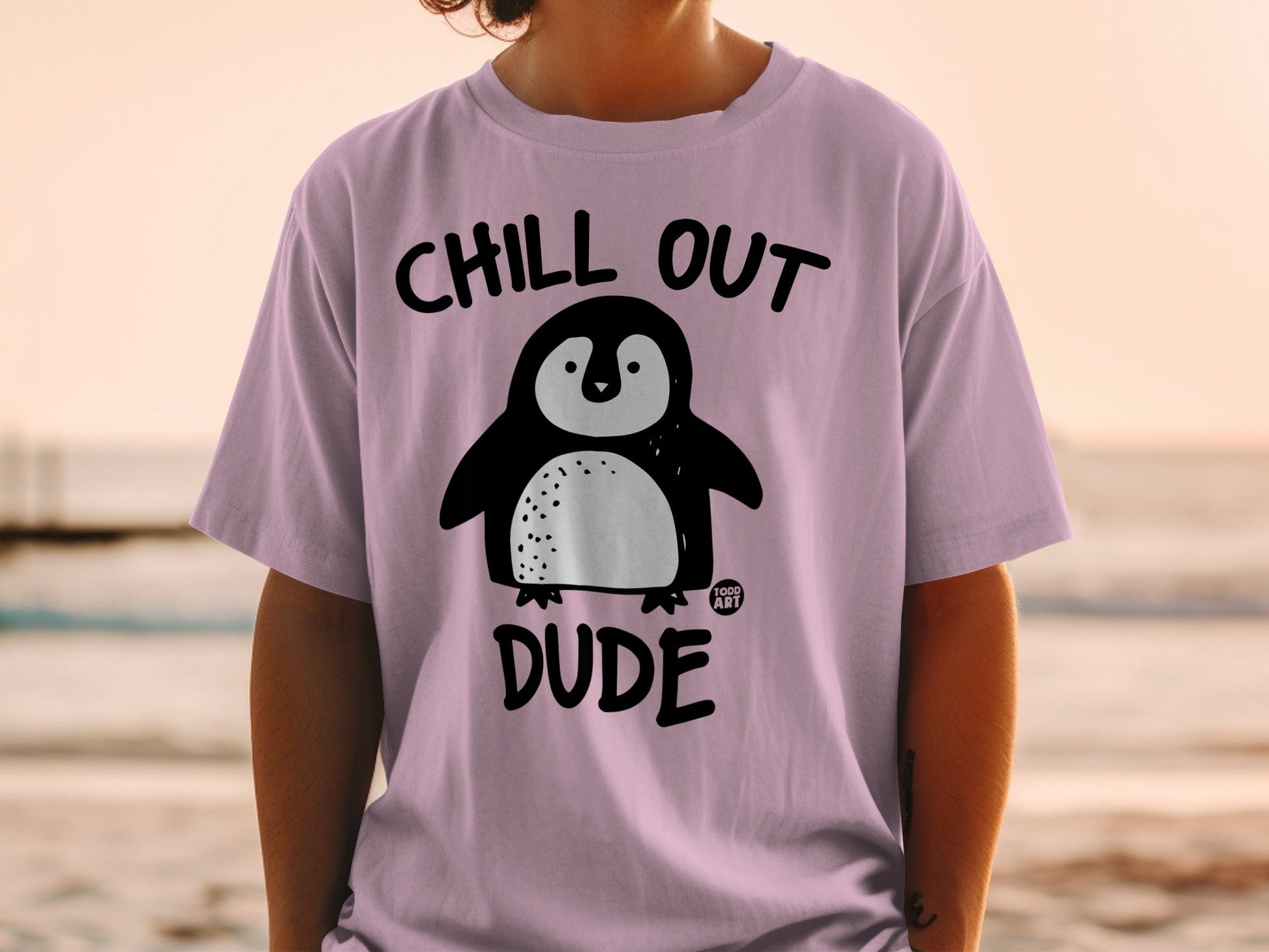 Pink t-shirt with a cartoon penguin and the text "CHILL OUT DUDE".
