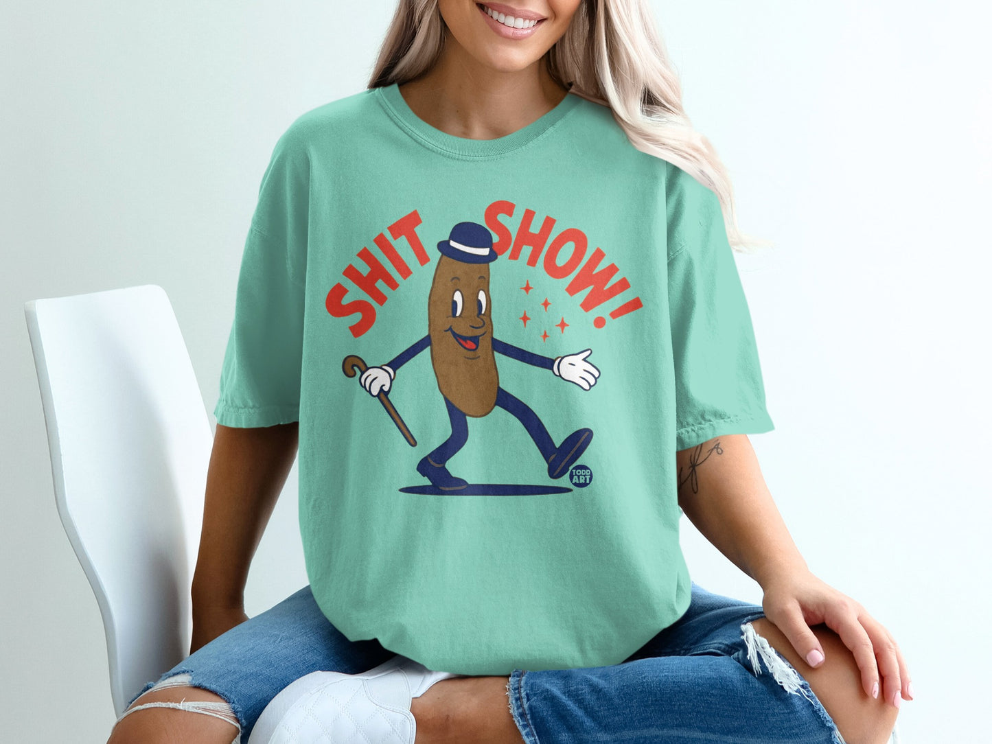 T-shirt with cartoon poop character in hat, holding cane, and text "SHIT SHOW!".