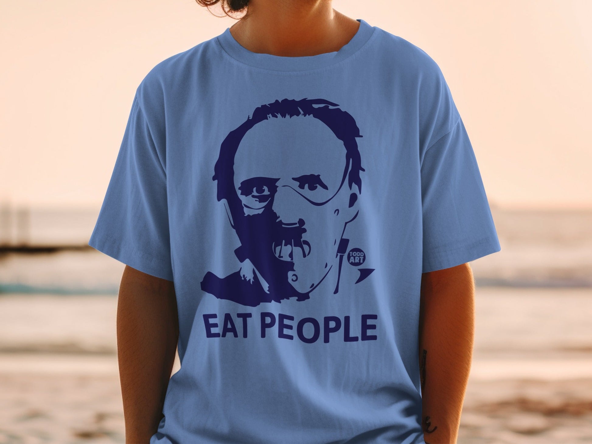 Blue t-shirt with a portrait and the words "EAT PEOPLE".