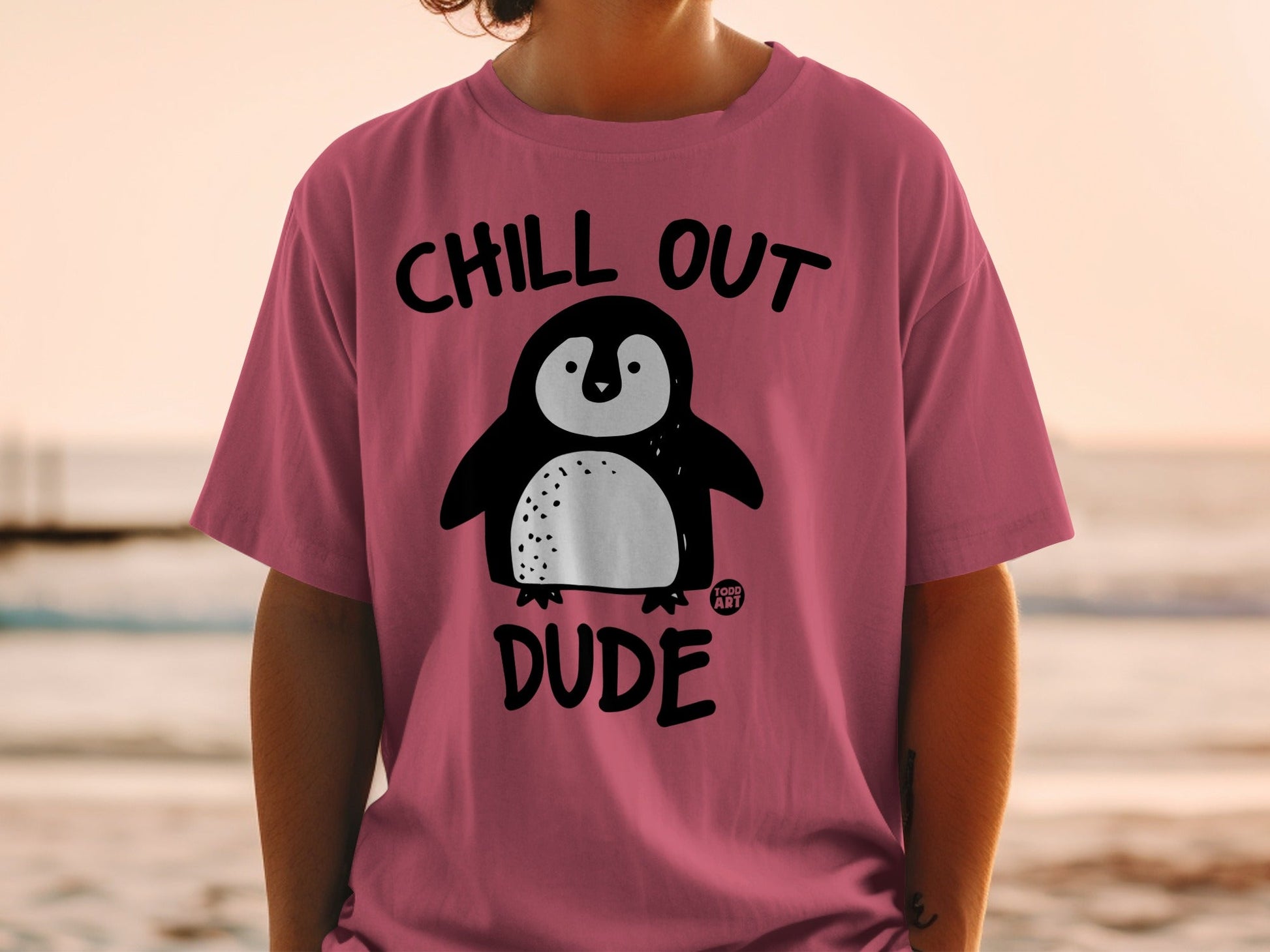 Pink t-shirt with a cartoon penguin and "Chill Out Dude" text.