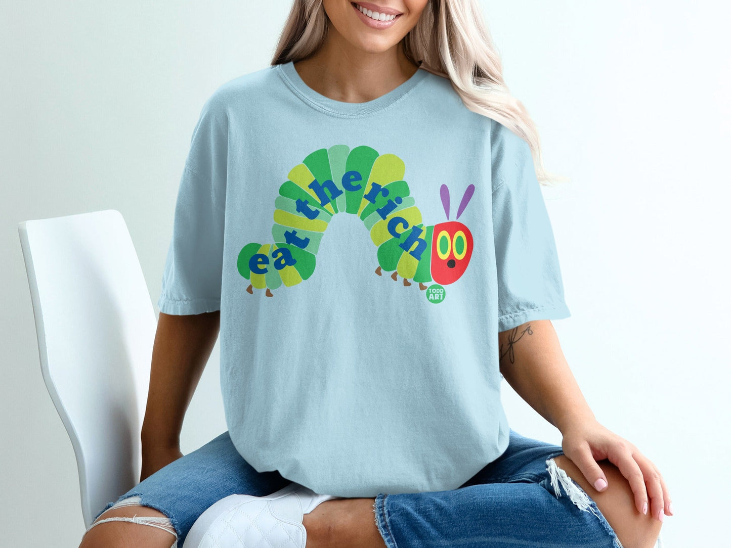 Light blue t-shirt with "eat the rich" caterpillar graphic and "food art" logo.