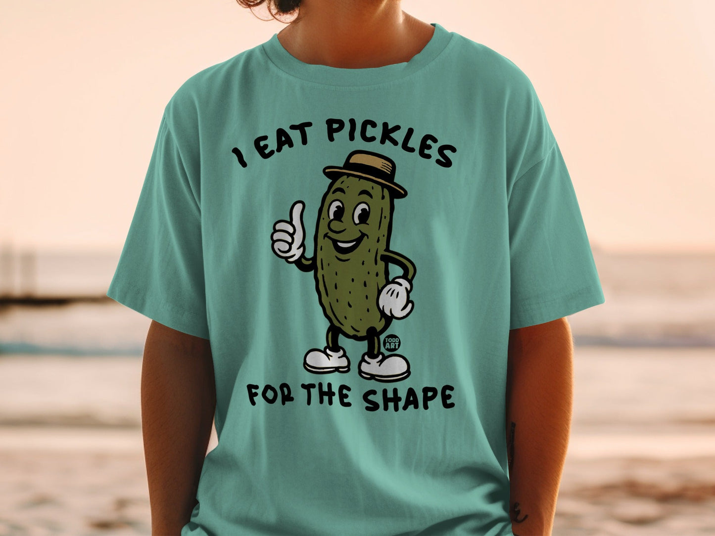 Cartoon pickle in a hat gives a thumbs up on a t-shirt.