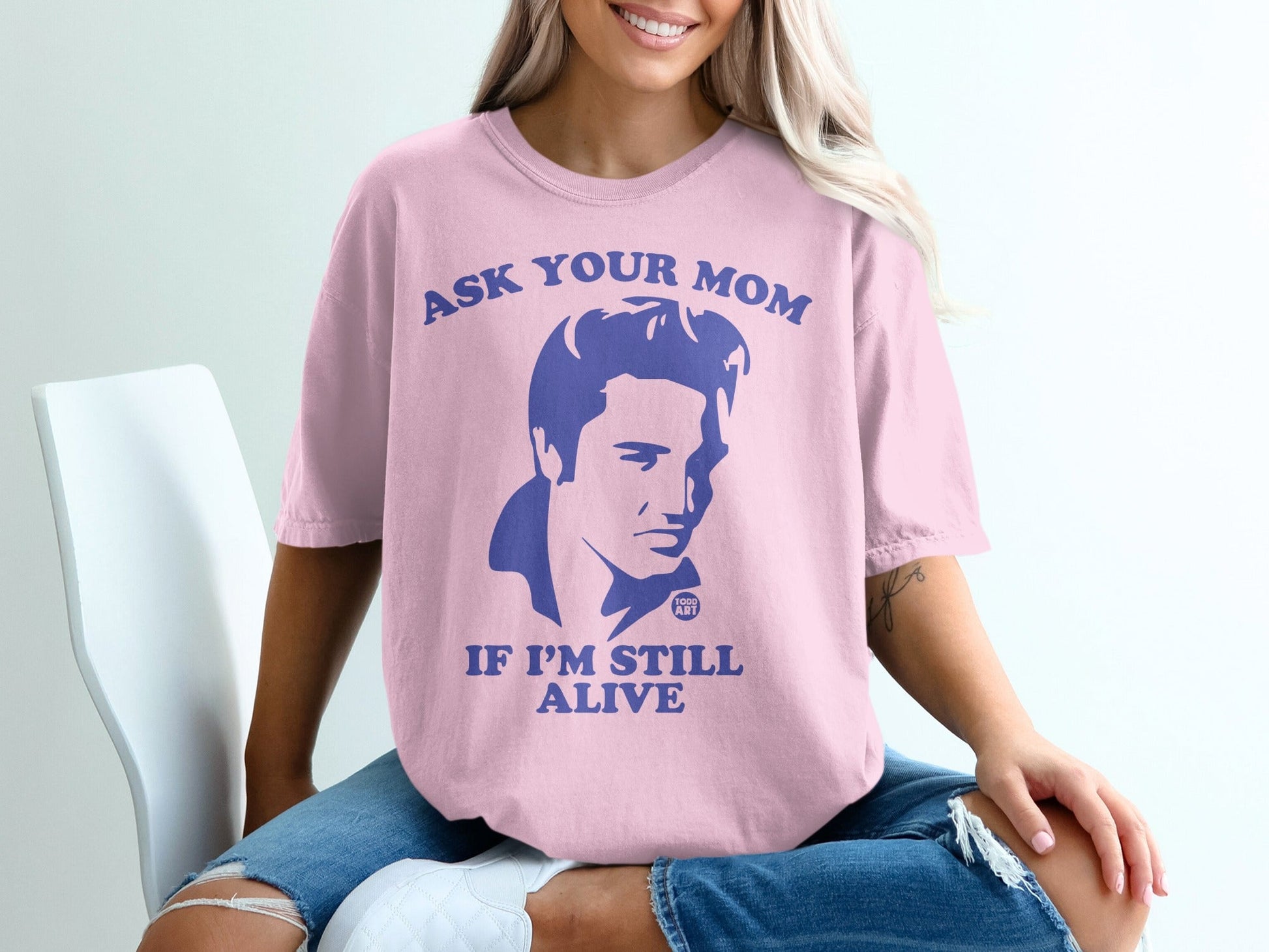Pink t-shirt with graphic of Elvis Presley and text "ASK YOUR MOM IF I'M STILL ALIVE".