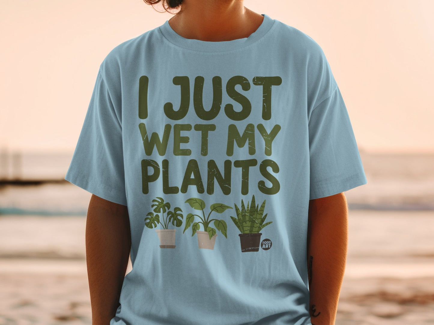 Light blue t-shirt with "I JUST WET MY PLANTS" and cartoon potted plants.