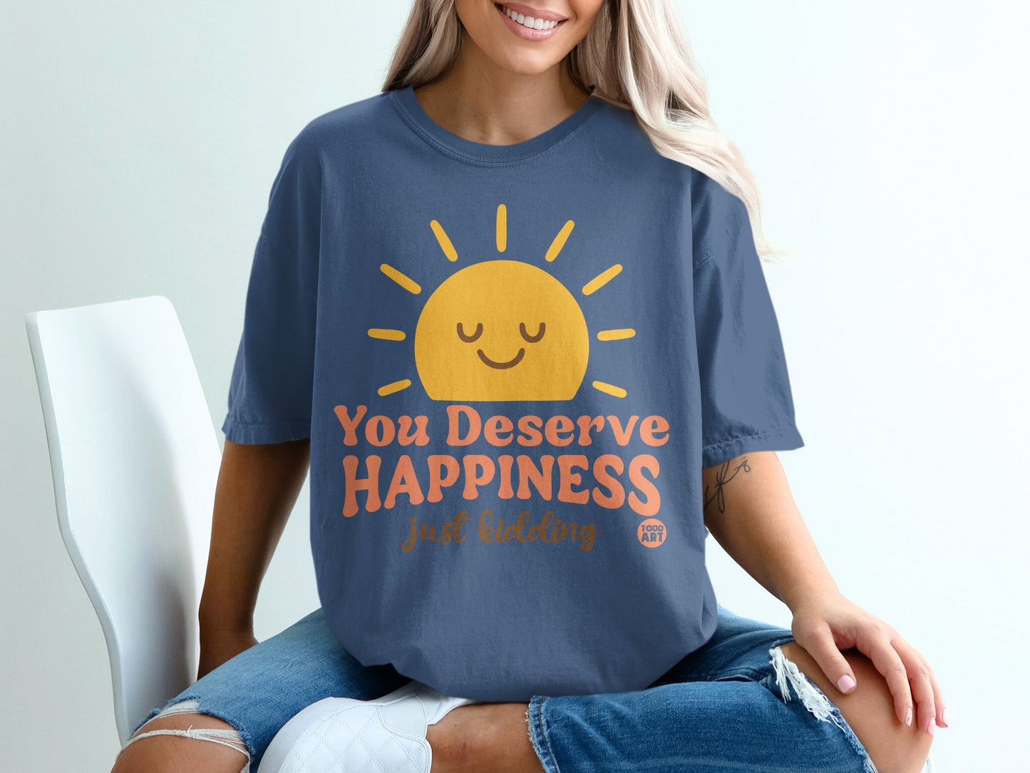 Blue t-shirt with a smiling sun and "You Deserve Happiness" text.