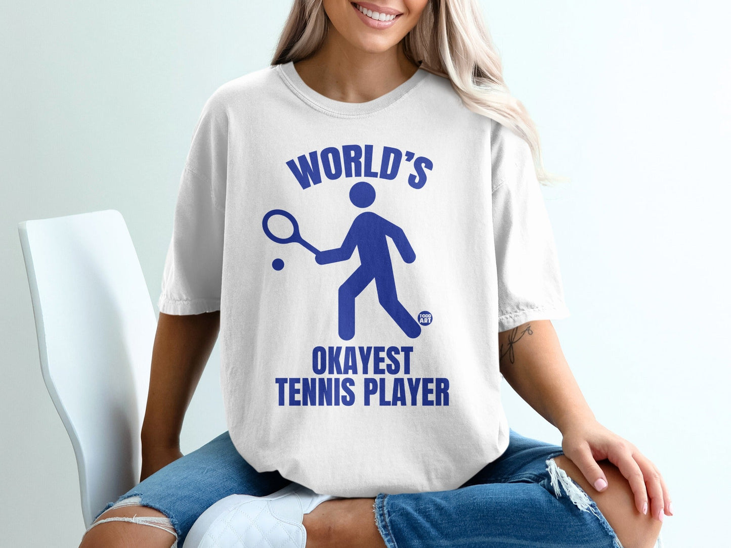 White t-shirt with blue text and tennis player graphic.