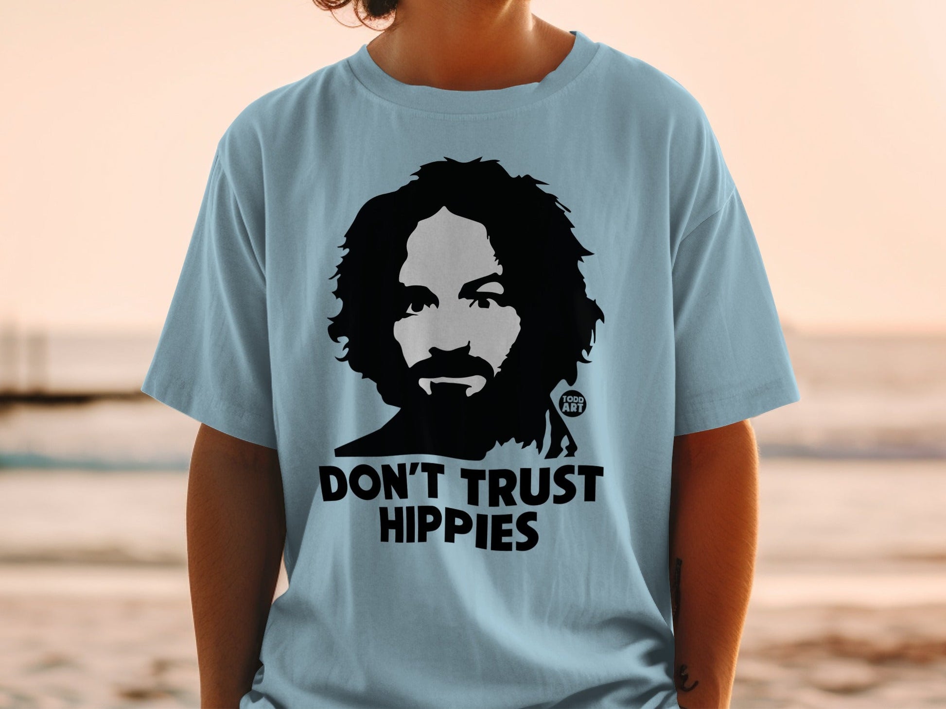 Light blue t-shirt with Charles Manson graphic and text "DON'T TRUST HIPPIES".