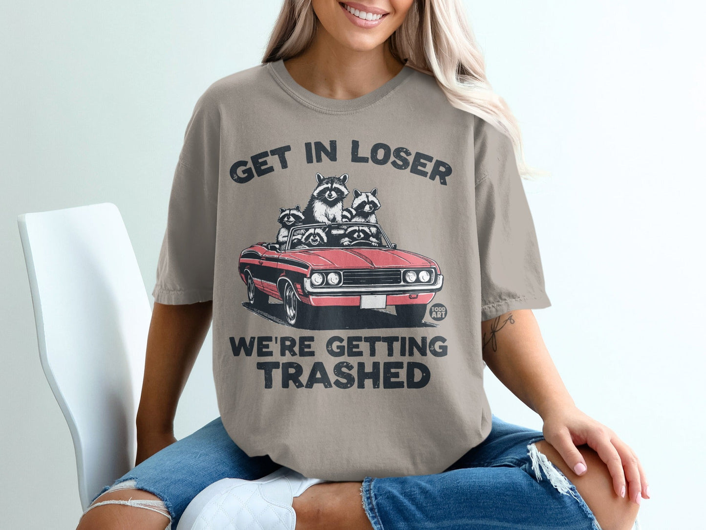 T-shirt with "Get In Loser We're Getting trashed" and raccoons in a convertible.