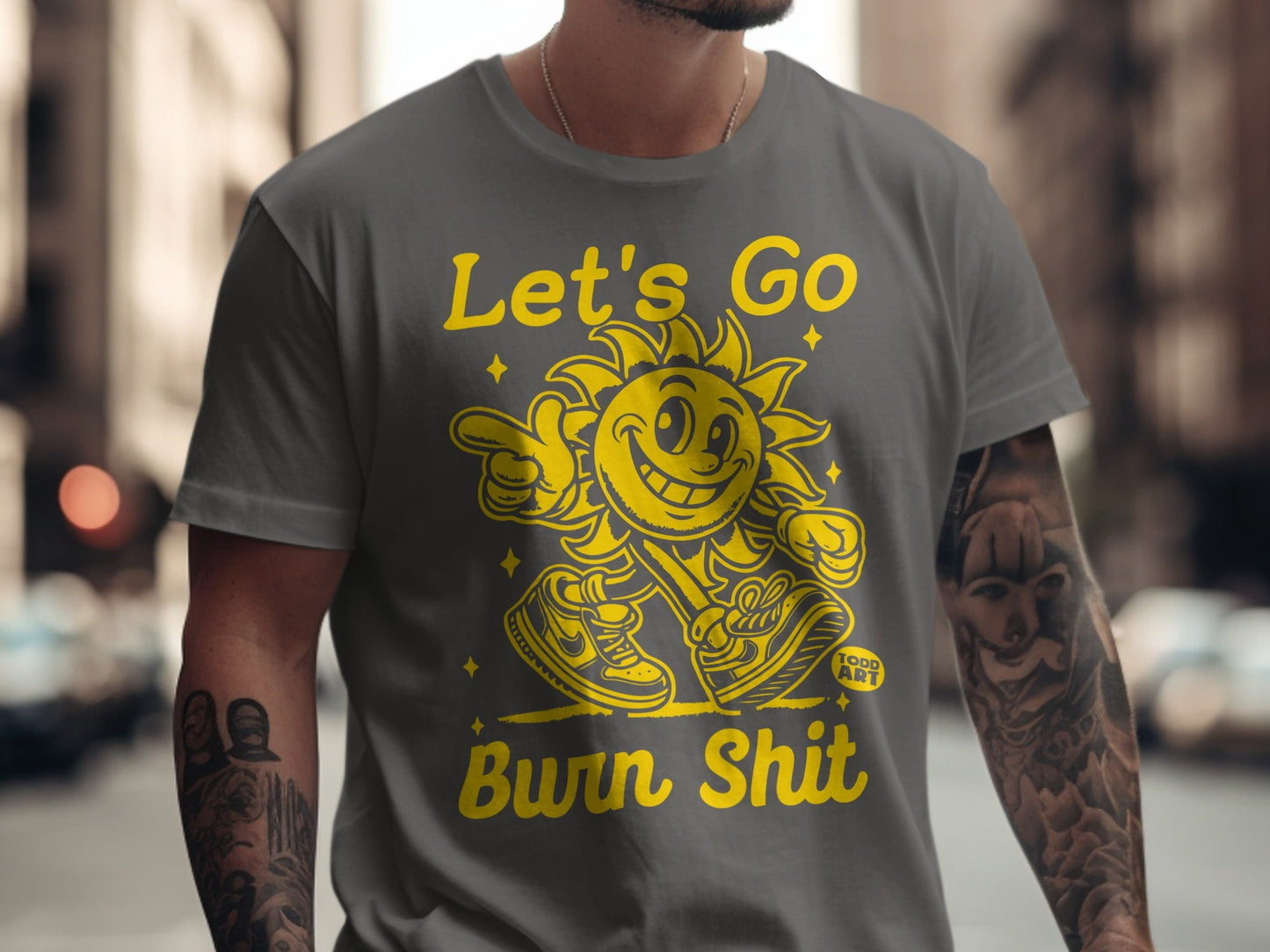 T-shirt with yellow graphic of a sun character saying "Let's Go Burn Shit".