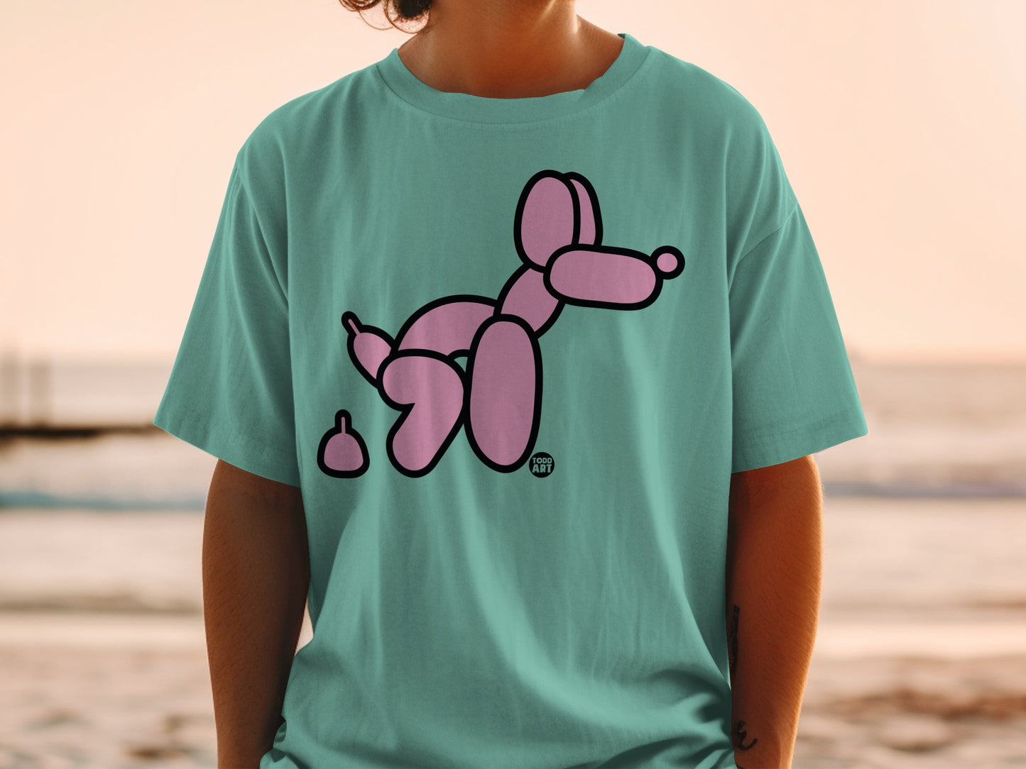 Teal t-shirt with a pink balloon dog and poop illustration.